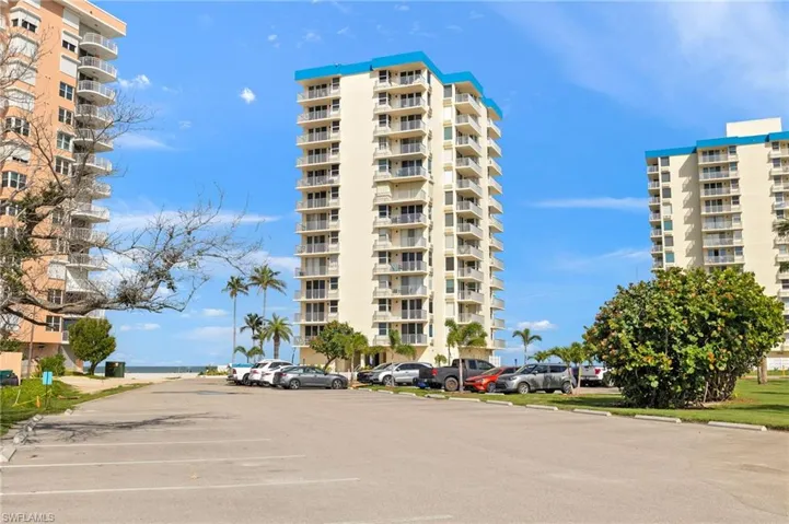 View of apartment building / complex featuring uncovered parking