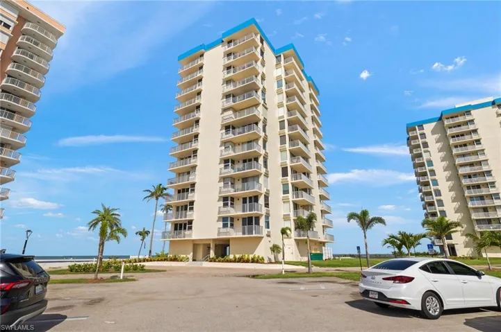 View of apartment building / complex featuring uncovered parking