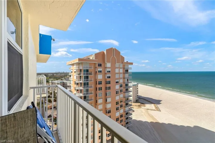 Balcony featuring view of water and beach