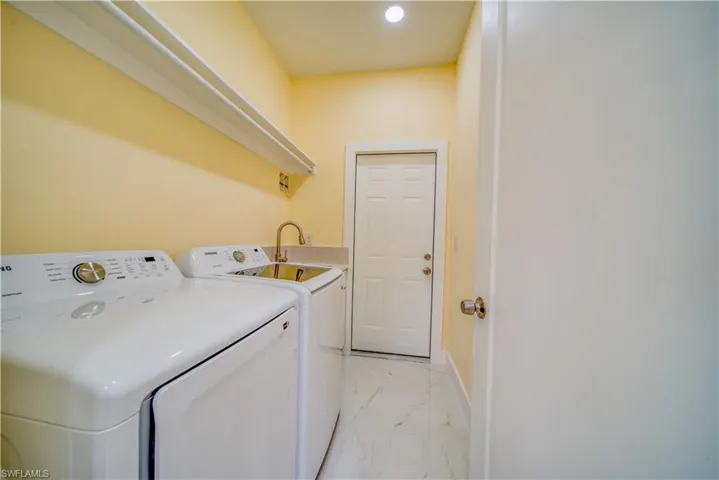 Laundry room featuring sink and separate washer and dryer
