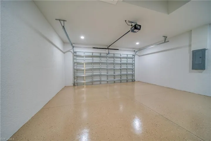 Garage featuring a garage door opener and electric panel