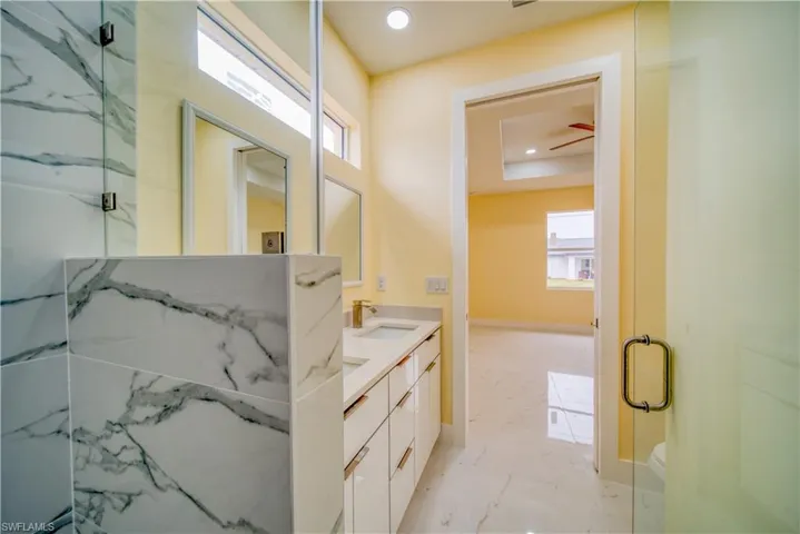 Bathroom with toilet, an enclosed shower, and vanity