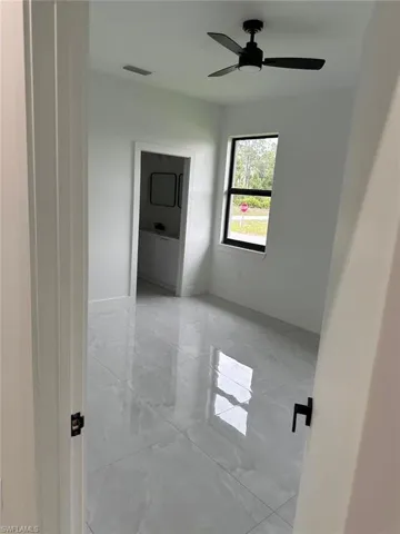 Unfurnished room featuring ceiling fan and light tile floors
