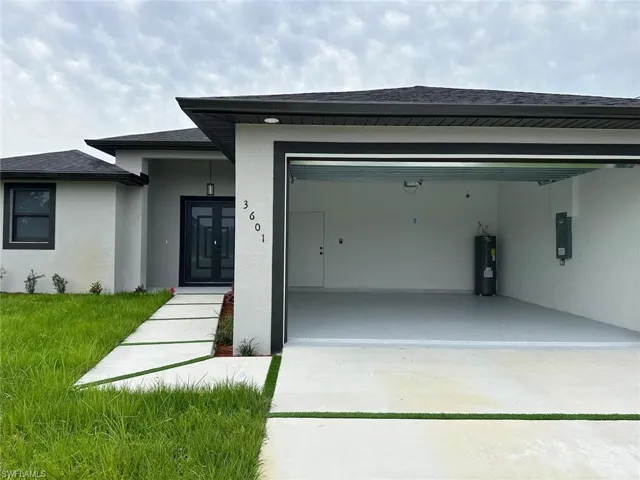 View of front of property with a garage and water heater