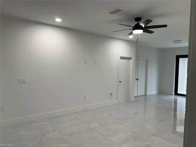 Tiled empty room with ceiling fan