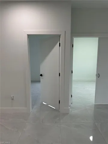 Corridor featuring light tile floors