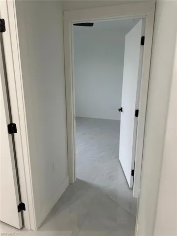 Hallway featuring light tile flooring