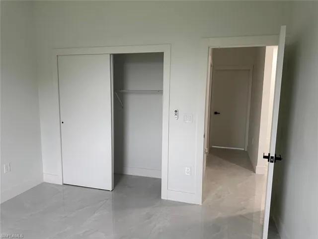 Unfurnished bedroom with a closet and light tile floors