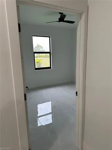 Tiled empty room featuring ceiling fan