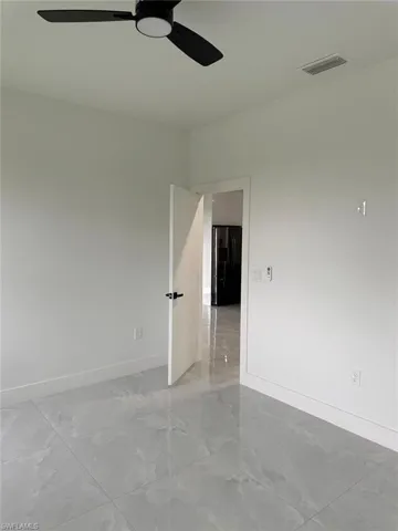Tiled spare room with ceiling fan