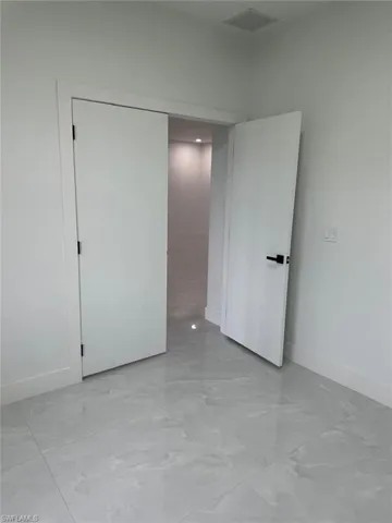 Unfurnished bedroom with light tile flooring