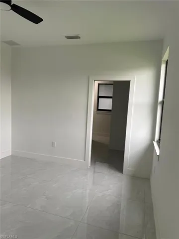 Tiled empty room featuring ceiling fan