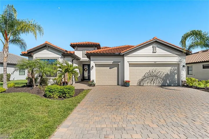 Mediterranean / spanish-style house featuring stucco siding, a tile roof, decorative driveway, and a garage