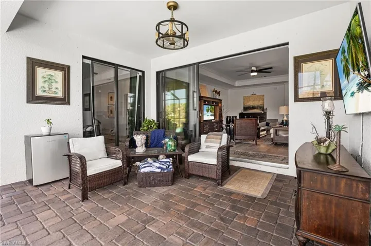 Sitting room with a raised ceiling, a ceiling fan, and crown molding