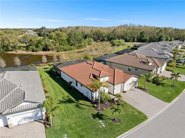 Birds eye view of property with a water view and a wooded view