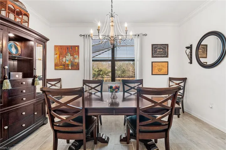 Dining room with ornamental molding, a chandelier, and baseboards