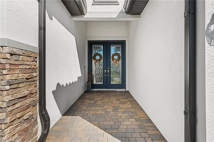 View of exterior entry with french doors and stucco siding