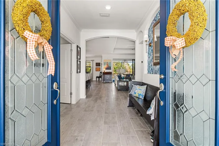 Entrance foyer with arched walkways, visible vents, and crown molding