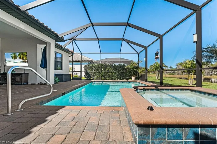 View of pool featuring a pool with connected hot tub, a lanai, and a patio