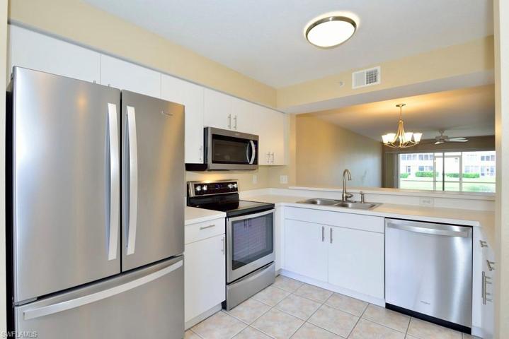 Crisp bright kitchen with gleaming stainless-steel appliances and view of the lake