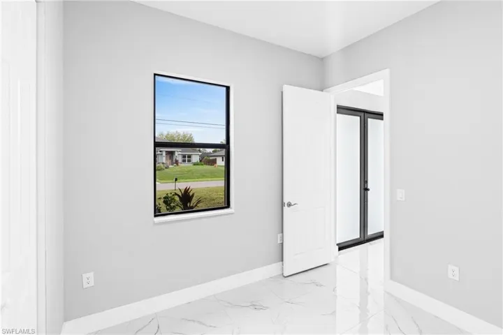 Empty room featuring light marble finish floors and baseboards