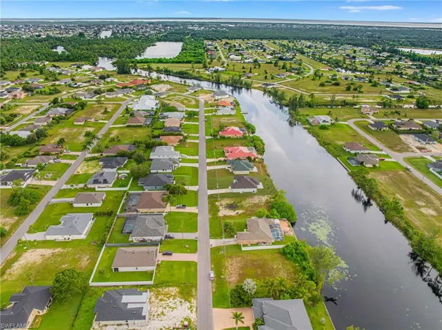 Aerial perspective of suburban area featuring a nearby body of water