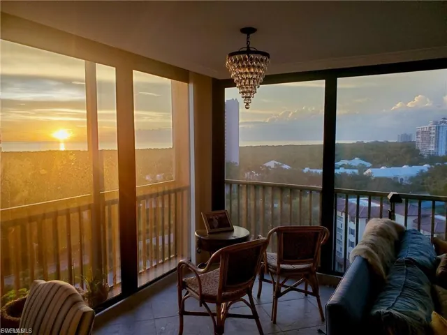 Expansive windows frame a scenic backdrop featuring a body of water and distant structures