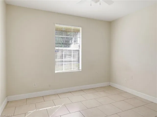 Spare room featuring ceiling fan and light tile patterned floors