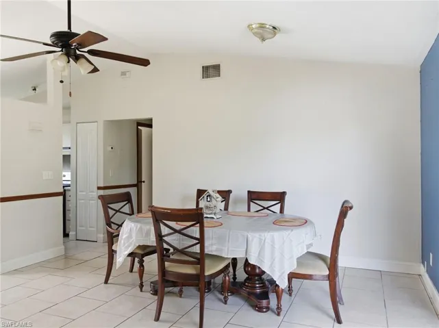 Dining room with lofted ceiling, a ceiling fan, and light tile patterned floors