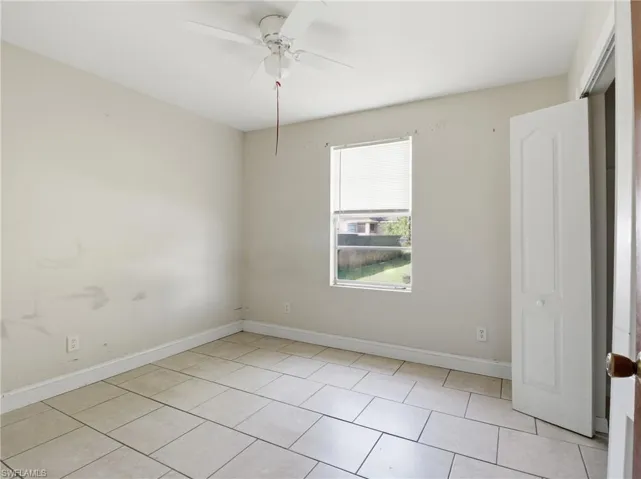 Unfurnished bedroom featuring ceiling fan and light tile patterned flooring