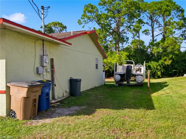 View of property exterior with a lawn and stucco siding