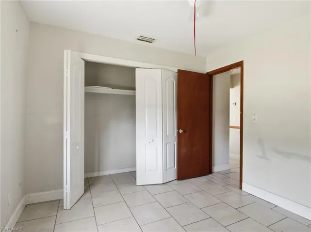 Unfurnished bedroom featuring a closet and light tile patterned floors