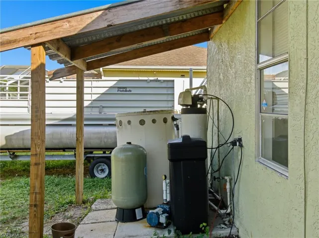 Exterior view of stucco siding and a water softener system