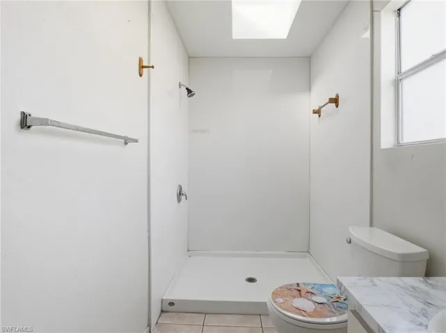 Bathroom featuring vanity, a stall shower, and light tile patterned floors