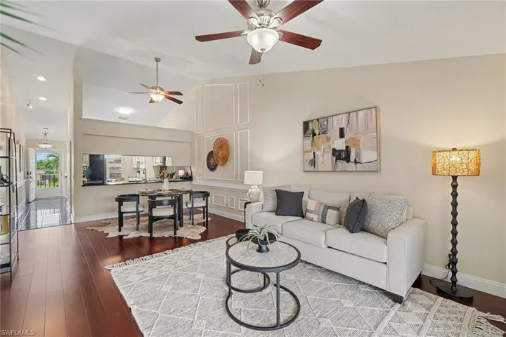 Vaulted ceilings with ceiling fans, wood-finish flooring, and crown molding