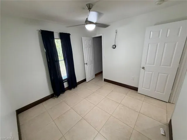 Recessed lighting, ceiling fan, tile flooring, six-panel interior doors, and a window with dark trim