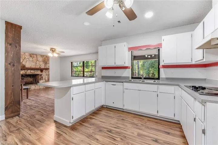 Kitchen with island for bar stool seating. Looking into your living room or formal dining room boasting a beautfiul stone fireplace.