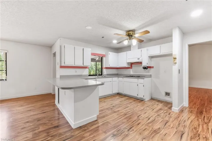 Kitchen featuring kitchen peninsula, vinyl wood-look flooring and recessed lighting