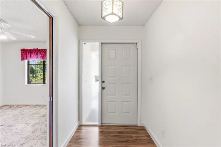 Foyer at the front door of the home. Spare room on the left-hand side with pocket door.