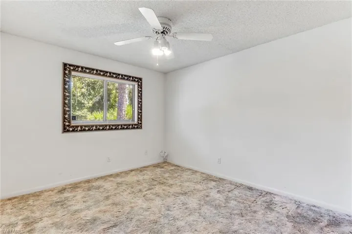 Guest bedroom featuring a textured ceiling, carpet, and ceiling fan. Closet not pictured.
