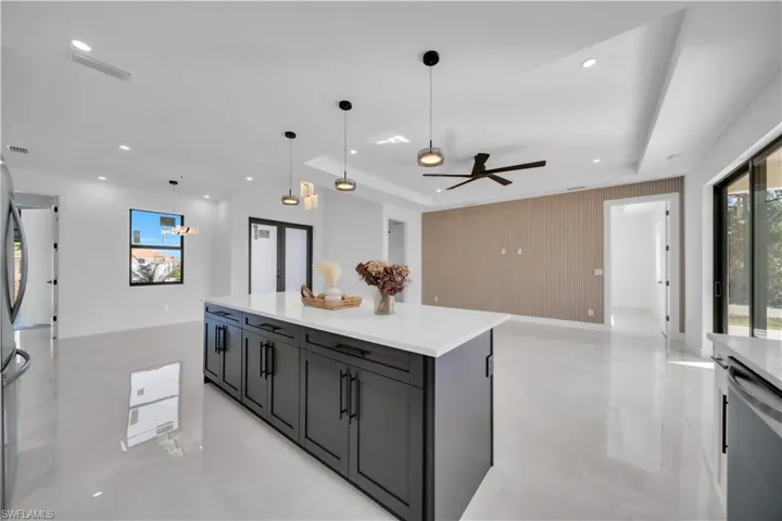Kitchen with plenty of natural light, open floor plan, hanging light fixtures, a kitchen island, and recessed lighting