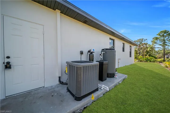 Exterior view of stucco siding and a water softener