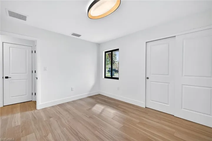 Unfurnished bedroom featuring light wood-style floors and a closet