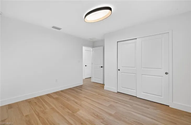 Unfurnished bedroom with light wood-style floors and a closet