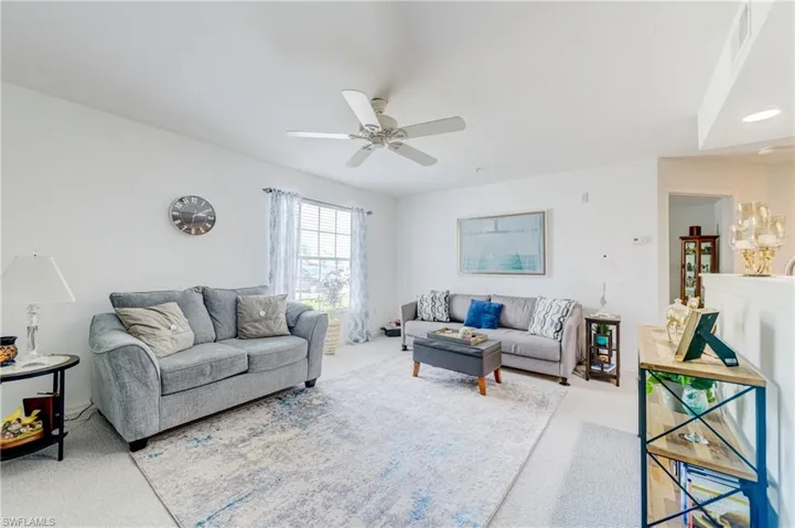 Living room with carpet flooring and ceiling fan