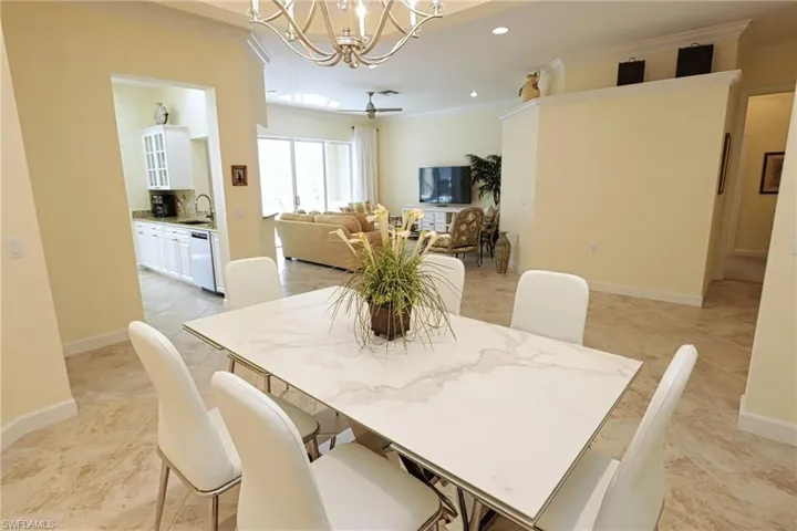 Dining room with light tile patterned floors, baseboards, a notable chandelier, ornamental molding, and recessed lighting