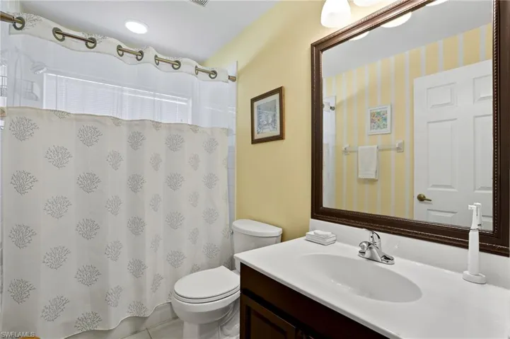 Bathroom featuring vanity, curtained shower, and light tile patterned floors