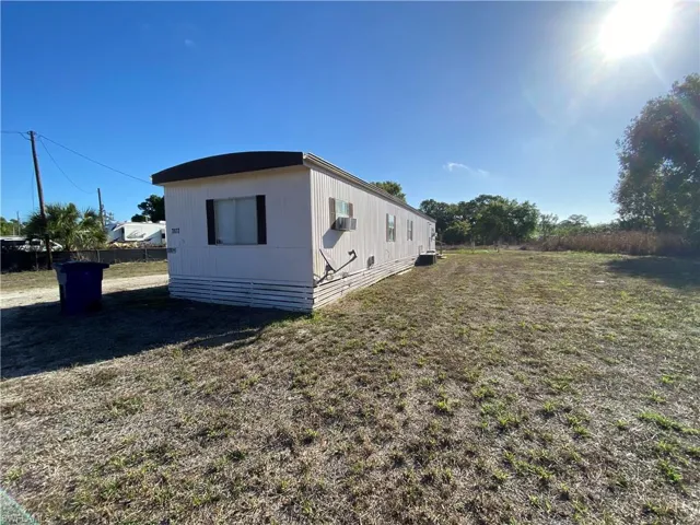 View of side of home with a central air condition unit