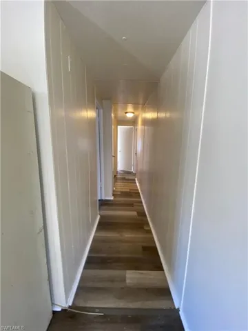 Hall featuring dark wood-style flooring
