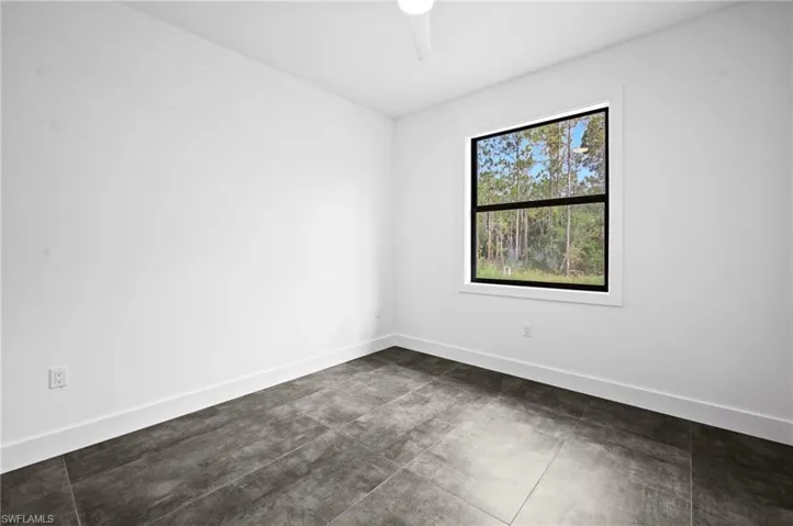 Spare room with a ceiling fan and concrete flooring